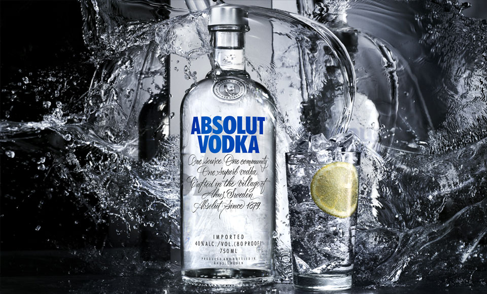Absolut Vodka bottle, glass, water.