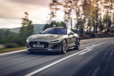 Gray coupe speeds through Australian road scenery.