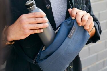 Person with gray bottle and blue eshay bag.