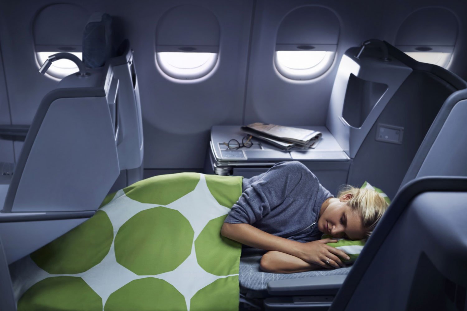 Person sleeps comfortably in business class seat.