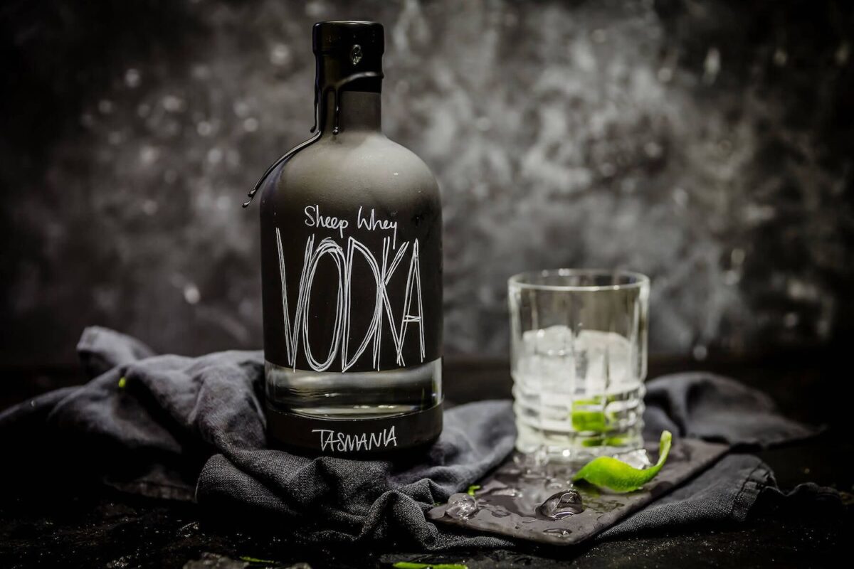 Sheep Whey Vodka bottle beside icy lime glass.